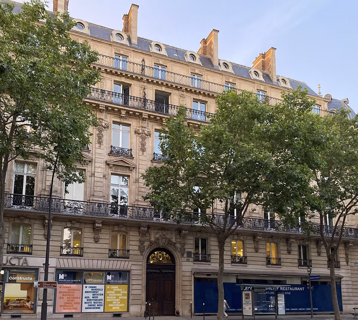Un immeuble de pierre et des arbres au 134 boulevard Haussmann, à Paris.